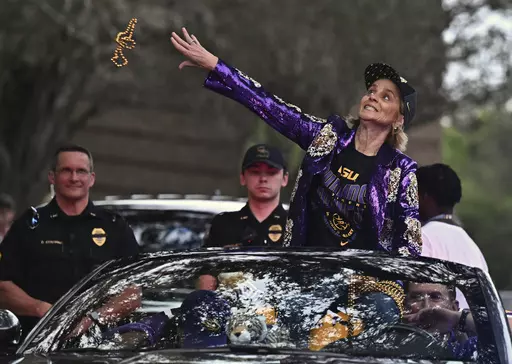LSU head coach Kim Mulkey throws beads into the crowd as the women's NCAA college national champion basketball team paraded across campus in Baton Rouge, La., Wednesday, April 5, 2023. (Hilary Scheinuk/The New Orleans Advocate via AP)