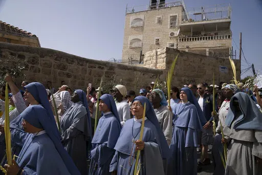 Nuns walk in the Palm Sunday procession on the Mount of Olives in Jerusalem, Sunday, April 10, 2022. (AP Photo/Maya Alleruzzo)