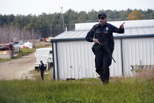 A police officer gives an order to the public during a manhunt for Robert Card at a farm following two mass shootings, Oct. 27, 2023, in Lisbon, Maine. Despite the warning by Card's friend and fellow Army reservist Sean Hodgson, which came alongside a series of other glaring red flags, Army officials discounted the warnings and ultimately did not stop Card from committing Maine's deadliest mass shooting when he killed multiple people in Lewiston. (AP Photo/Robert F. Bukaty, File)