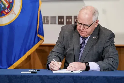 Gov. Tim Walz signs into law a sweeping package of police accountability measures in St. Paul, Minn., on July 23, 2020, including a ban on neck restraints, in the wake of George Floyd's death. (Glen Stubbe/Star Tribune via AP, File)