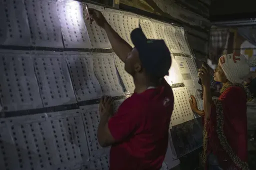 Voters look for their names outside a polling station in Goma, eastern Democratic Republic of the Congo, Wednesday, Dec. 20, 2023. Congo headed to the polls Wednesday to vote for president as authorities scrambled to finalise preparations in an election facing steep logistical and security challenges. (AP Photo/Moses Sawasawa)