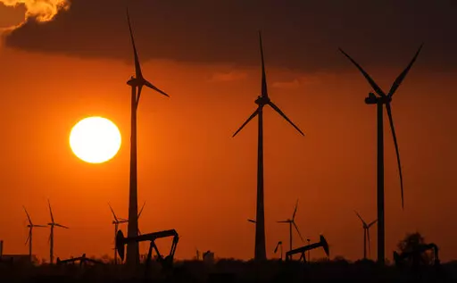 FILE -Wind turbines produce power during sundown in Emlichheim, Germany, Friday, March 18, 2022. The head of the International Renewable Energy Agency says “radical action” is needed to ensure global warming doesn't pass dangerous thresholds, warning that greenhouse gas emissions are heading in the wrong direction.(AP Photo/Martin Meissner,file)