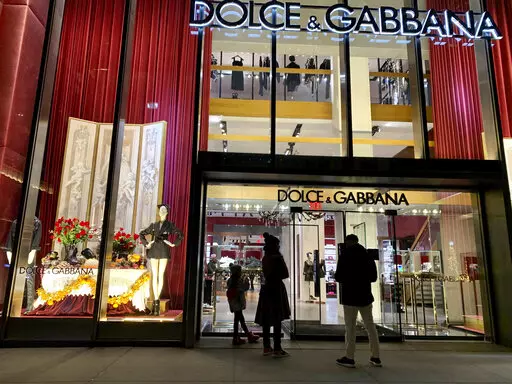 People stand outside the Dolce & Gabbana store on Fifth Avenue, Nov. 21, 2021, in New York. Dolce & Gabbana announced Monday, Jan. 31, 2022 that it will drop the use of animal fur in all its collections starting this year, and transition to eco-friendly faux fur. The Milan fashion house joins other luxury brands, including Armani, Gucci, Prada and Moncler, in adhering to guidelines set by the Fur Free Alliance, a network of animal rights groups around the world. (AP Photo/Pamela Hassell, file)