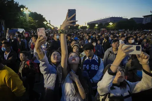 People take smartphone photos of the crowd on a street near Tiananmen Square as visitors gather to watch a flag-raising ceremony on the National Day in Beijing, Sunday, Oct. 1, 2023. The world’s population is expected to grow by more than 2 billion people in the next decades and peak in the 2080s at around 10.3 billion, a new report by the United Nations said Thursday July 11, 2024. (AP Photo/Andy Wong, File)