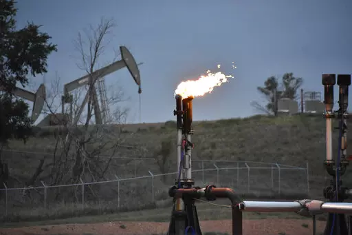 A flare to burn methane from oil production is seen on a well pad near Watford City, N.D., on Aug. 26, 2021. The U.S. government this week is holding its first onshore oil and gas sales from public lands since President Joe Biden took office. (AP Photo/Matthew Brown, File)