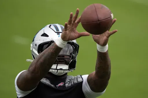 Carolina Panthers running back Miles Sanders reacts for a catch during the NFL football team's training camp in Charlotte, N.C., Sunday, Aug. 4, 2024. (AP Photo/Chuck Burton)