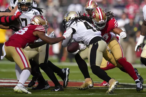 New Orleans Saints running back Alvin Kamara, middle, fumbles the ball between San Francisco 49ers cornerback Deommodore Lenoir, left, and linebacker Fred Warner during the first half of an NFL football game in Santa Clara, Calif., Sunday, Nov. 27, 2022. The 49ers recovered the ball. (AP Photo/Godofredo A. Vásquez)