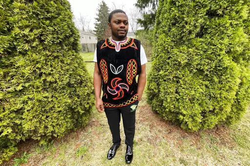 Wilfred Tebah, who fled Cameroon during its ongoing conflict, poses for a photo in the backyard of his home, Thursday, March 31, 2022, in Columbus, Ohio. African refugees say the recent decision to grant Ukrainians fleeing war refugee status and other humanitarian protections underscores the racial bias inherent in American immigration policy. Tebah says he and other immigrants from Cameroon have long been deserving of similar humanitarian considerations. (AP Photo/Patrick Orsagos)
