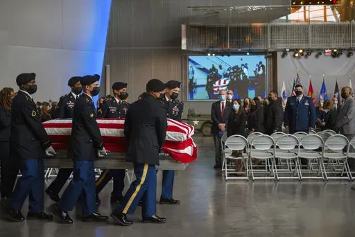The casket of Lawrence Brooks, who had been the oldest living World War II Veteran, is carried at a memorial service at The National World War II Museum in New Orleans, Saturday, Jan. 15, 2022. Brooks, who died Jan. 5, was 112. (AP Photo/Kathleen Flynn)