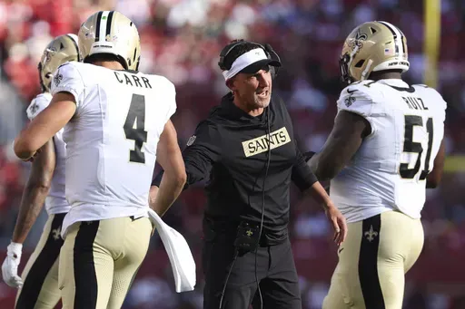 New Orleans Saints head coach Dennis Allen, middle, celebrates with quarterback Derek Carr (4) and center Cesar Ruiz (51) during the first half of a preseason NFL football game against the San Francisco 49ers in Santa Clara, Calif., Sunday, Aug. 18, 2024. (AP Photo/Jed Jacobsohn)