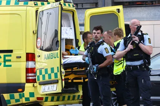 An ambulance and armed police outside the Field's shopping center, in Orestad, Copenhagen, Denmark, Sunday, July 3, 2022, after reports of shots fired. Danish police say several people have been shot at a Copenhagen shopping mall. Copenhagen police said that one person has been arrested in connection with the shooting at the Field’s shopping mall on Sunday. Police tweeted that “several people have been hit” but gave no other details. (Olafur Steinar Gestsson /Ritzau Scanpix via AP)