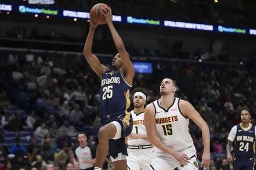 New Orleans Pelicans guard Trey Murphy III (25) goes to the basket ahead of Denver Nuggets center Nikola Jokic (15) and forward Michael Porter Jr. (1) in the first half of an NBA basketball game in New Orleans, Sunday, Dec. 22, 2024. (AP Photo/Gerald Herbert)