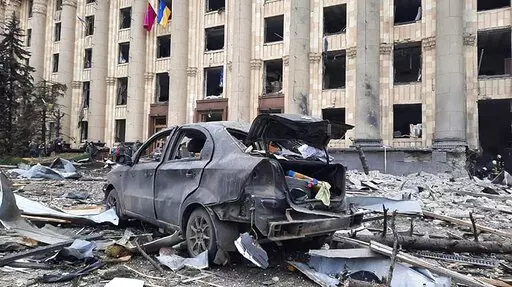In this handout photo released by Ukrainian Emergency Service, a burnt car is seen in front of a damaged City Hall building, in Kharkiv, Ukraine, Tuesday, March 1, 2022. Russian shelling pounded civilian targets in Ukraine's second-largest city, Kharkiv, Tuesday and a 40-mile convoy of tanks and other vehicles threatened the capital - tactics Ukraine's embattled president said were designed to force him into concessions in Europe's largest ground war in generations. (Ukrainian Emergency Service 