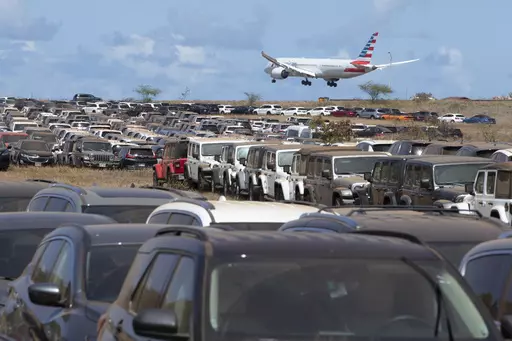 Unused rental cars are parked in an overflow lot at Kahului Airport in Kahului, Hawaii, on Aug, 14. 2023. So few tourists are coming to the Hawaiian island of Maui after last month's wildfires that restaurants and tour companies are laying off workers and unemployment is surging. State tourism officials initially urged travelers to stay away but now want them to come back so long as they refrain from going to the burn zone and surrounding area. (George F. Lee/Honolulu Star-Advertiser via AP)