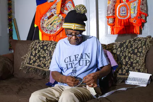 Big Chief Monk Boudreaux sits in his home in New Orleans on Sunday, Feb. 20, 2022, preparing for Fat Tuesday and the Grammy awards. At 80 years old, Boudreaux is head of a Mardi Gras Indians group called the Golden Eagles, known both as a leading elders of the tradition and for a musical career that has spanned decades and taken him far from his hometown. This year finds Boudreaux preparing for both the first Fat Tuesday celebration in two years after the pandemic canceled last year's festivitie