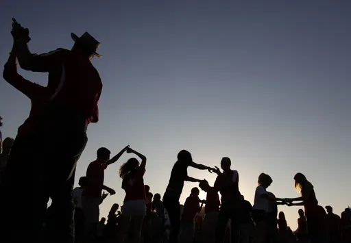 Tailgaters dance the Cajun two step to the Gino Delafose and French Rockin' Boogie zydeco band as a kickoff for the annual Festival Acadiens et Creoles in Lafayette, La., Oct. 8, 2010. (AP Photo/Gerald Herbert, File)