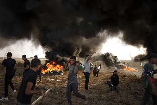 Palestinians burn tires during a protest against Israeli military raid in the West Bank, along the border fence with Israel, in east of Gaza City on Oct. 25, 2022. The U.N. Mideast envoy said 2022 is on course to be the deadliest year for Palestinians in the West Bank since the U.N. started tracking fatalities in 2005, and he called for immediate action to calm "an explosive situation" and move toward renewing Israeli-Palestinian negotiations. (AP Photo/Fatima Shbair, File)