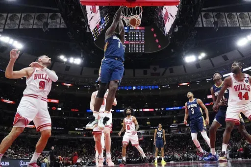 New Orleans Pelicans forward Zion Williamson (1) hangs from the rim after dunking during the second half of an NBA basketball game against the Chicago Bulls in Chicago, Tuesday, Jan. 14, 2025. The Pelicans won 119-113. (AP Photo/Nam Y. Huh)