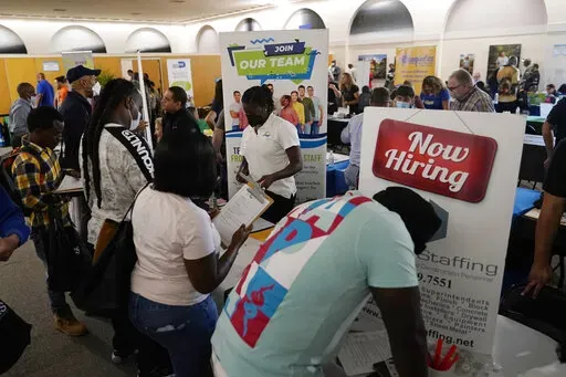 Job applicants fill out forms with CSC Global, left, and Skilled Staffing, right, at the 305 Second Chance Job & Resource Expo, Friday, June 10, 2022, in Miami. America’s employers shrugged off high inflation and weakening growth to add 372,000 jobs in June, a surprisingly strong gain that will likely spur the Federal Reserve to keep sharply raising interest rates to try to cool the economy and slow price increases. The unemployment rate remained at 3.6% for a fourth straight month, the govern