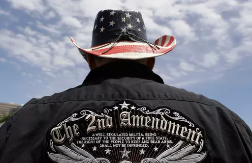 A man wears a patriotic-themed cowboy hat during a pro gun-rights rally at the Texas Capitol, April 14, 2018, in Austin, Texas. Guns have long been a part of Texas culture — both in the state’s mythology and in reality. But to equate the number of guns with the number of people killed by guns strikes some as a false equivalence. (AP Photo/Eric Gay, File)