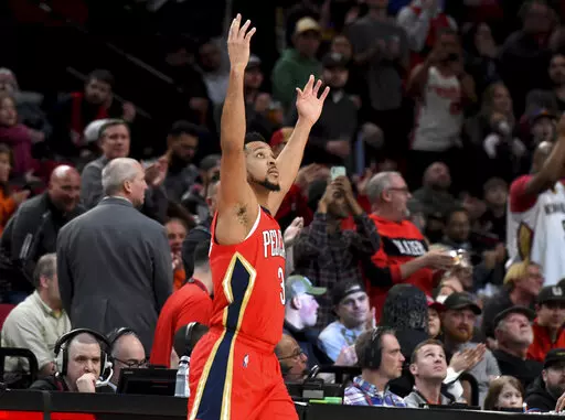 New Orleans Pelicans guard CJ McCollum reacts to the fans as he enters the game after a timeout in which a highlight video of him as a Portland Trail Blazer was played, during the first half of an NBA basketball game in Portland, Ore., Wednesday, March 30, 2022. It was the first game back in Portland for the longtime Blazer, who was traded to the Pelicans in February. (AP Photo/Steve Dykes)