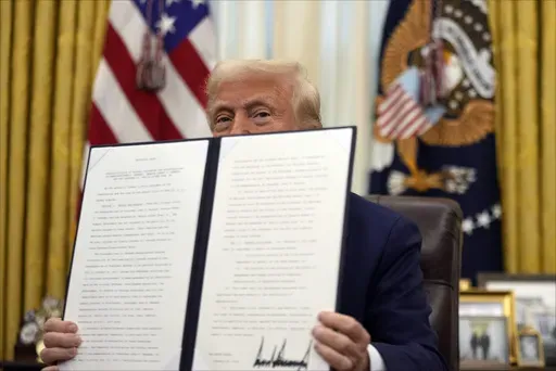 President Donald Trump holds a signed an executive order regarding the declassification and release of records relating to the assassinations of former President John F. Kennedy, Sen. Robert F. Kennedy and Rev. Martin Luther King, Jr., in the Oval Office of the White House, Thursday, Jan. 23, 2025, in Washington. (AP Photo/Ben Curtis)