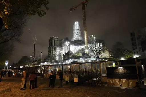 Notre-Dame de Paris cathedral is seen with its spire surrounded by scaffolding Tuesday, Dec. 5, 2023 in Paris. The restoration of Notre Dame hits a milestone Friday, Dec. 8, 2023: one year until the cathedral reopens its huge doors to the public. (AP Photo/Thibault Camus)