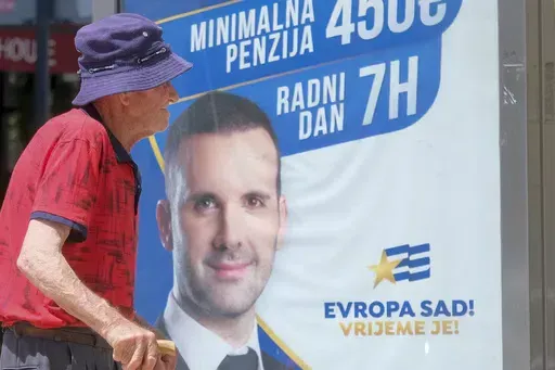 A man walks past a pre-election billboard showing leader of the Europe Now movement, financial expert Milojko Spajic in Podgorica, Montenegro, Friday, June 9, 2023. Montenegro is holding an early parliamentary election Sunday, a vote that could provide indications of whether the small NATO member in the Balkans will overcome the deep political divisions and instability that have hampered its route to joining the European Union. (AP Photo/Risto Bozovic)