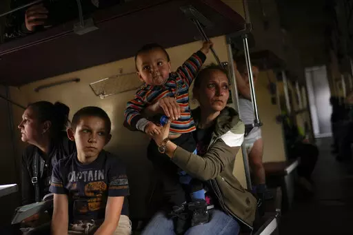 Yana Skakova and her son Yehor who fled from Lysychansk with other people sit in an evacuation train at the train station in Pokrovsk, eastern Ukraine, eastern Ukraine, Saturday, May 28, 2022. Fighting has raged around Lysychansk and neighbouring Sievierodonetsk, the last major cities under Ukrainian control in Luhansk region. (AP Photo/Francisco Seco)