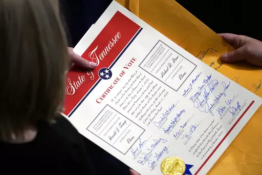 Staff members hold the certification of Electoral College votes from Tennessee during a joint session of the House and Senate to confirm Electoral College votes at the Capitol, early Jan 7, 2021, in Washington. Former President Donald Trump's relentless, false claims about the 2020 presidential election have sparked fresh urgency in Congress for changing the Electoral Count Act. (AP Photo/Andrew Harnik, File)