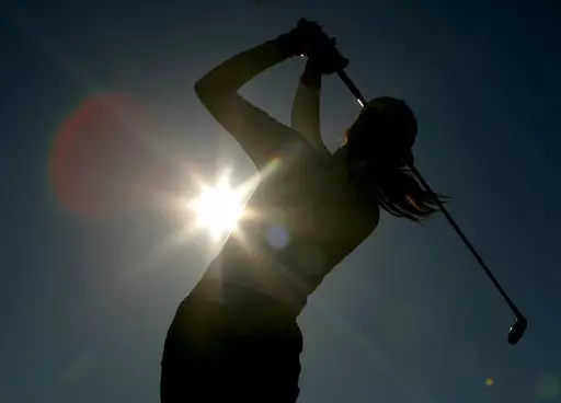 A golfer is silhouetted against the sun while teeing off on the third hole during the first round of the Women's British Open golf tournament at Royal Lytham and St Annes golf course in Lytham, north west England Thursday, Aug. 3, 2006. Kerry Bowie's daughters have dreams. Big ones. “There are some things people miss out on by not doing it,” Bowie says. “To be that young lady who plays golf, it changes things.” (AP Photo/Matt Dunham, File)