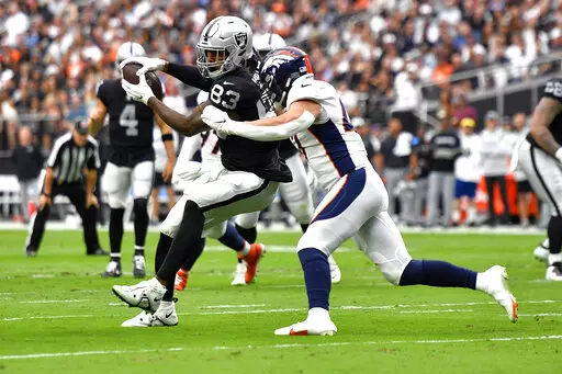 Las Vegas Raiders tight end Darren Waller (83) pulls in a catch as Denver Broncos linebacker Josey Jewell defends during the first half of an NFL football game, Sunday, Oct. 2, 2022, in Las Vegas. (AP Photo/David Becker)