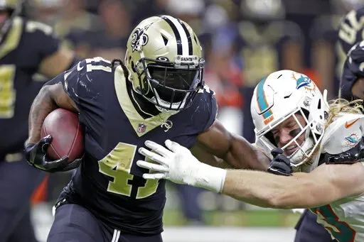 Miami Dolphins' Andrew Van Ginkel, right, reaches to tackle New Orleans Saints running back Alvin Kamara (41) during the second half of an NFL football game Monday, Dec. 27, 2021, in New Orleans. (AP Photo/Butch Dill)