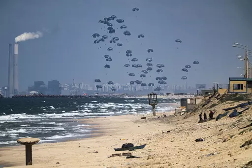 An aircraft airdrops humanitarian aid over the northern Gaza Strip, as seen from central Gaza, Monday, March 25, 2024. (AP Photo/Fatima Shbair)