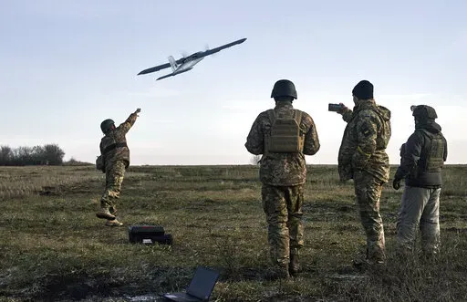 Ukrainian soldiers launch a drone at Russian positions near Bakhmut, Donetsk region, Ukraine, Thursday, Dec. 15, 2022. (AP Photo/LIBKOS)