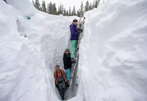 Working inside a nearly 18-foot-deep snow pit at the UC Berkeley Central Sierra Snow Lab, from left, Shaun Joseph, Claudia Norman, Helena Middleton take measurements of snow temperatures ahead of a weather storm on March 9, 2023, in Soda Springs, Calif. A new study finds the snow deluge in California, which quickly erased a two decade long megadrought, was essentially a once-in-a-lifetime rescue from above. The study authors coined the term “snow deluge” for one-in-20-year heavy snowfalls. (