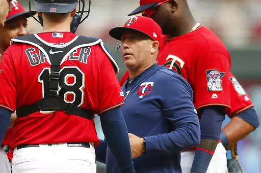 Minnesota Twins pitching coach Wes Johnson, right, holds a meeting on the mound with pitcher Taylor Rogers and catcher Mitch Garver during a baseball game in Minneapolis on Aug. 11, 2019. Johnson has informed the club he will leave his job, reportedly for the same role at LSU. (AP Photo/Jim Mone)