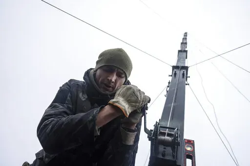 Ukrainian servicemen from 127 brigade prepare a telescopic tower with a remote camera installed on a Soviet car "Volga" that was recast to observe and correct fire on the front line near Kharkiv, Ukraine, Sunday, Dec. 25, 2022. (AP Photo/Evgeniy Maloletka)