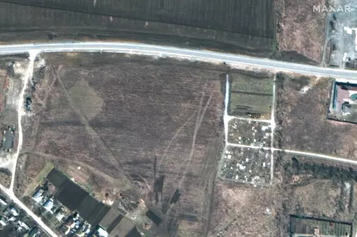 This satellite image provided by Maxar Technologies on Thursday, April 21, 2022 shows an overview of the cemetery in Manhush, some 20 kilometers west of Mariupol, Ukraine, on March 19, 2022. (Satellite image ©2022 Maxar Technologies via AP)