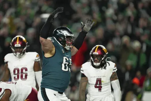 Philadelphia Eagles offensive tackle Lane Johnson (65) celebrates a touchdown by quarterback Jalen Hurts during the second half of the NFC Championship NFL football game against the Washington Commanders, Sunday, Jan. 26, 2025, in Philadelphia. (AP Photo/Derik Hamilton)