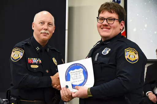 In this photo obtained from the Memphis Police Department's Facebook page, Preston Hemphill receives a certificate from Memphis Assistant Chief of Police Don Crowe after completing the training to join the department's Crisis Intervention Team on July 21, 2022. Police officials said Monday, Jan. 30, 2023, that Hemphill and another officer were relieved of duty in connection with the death of Tyre Nichols, widening the circle of punishment for the shocking display of police brutality after video 