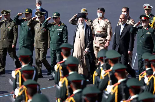 In this picture released by the official website of the office of the Iranian supreme leader, Supreme Leader Ayatollah Ali Khamenei, center, reviews a group of armed forces cadets during their graduation ceremony accompanied by commanders of the armed forces, at the police academy in Tehran, Iran, Monday, Oct. 3, 2022. Khamenei responded publicly on Monday to the biggest protests in Iran in years, breaking weeks of silence to condemn what he called “rioting” and accuse the U.S. and Israel of
