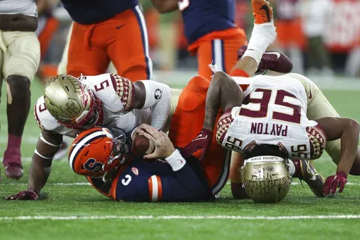 Florida State defensive linemen Jared Verse (5) and Patrick Payton (56) sack Syracuse quarterback Garrett Shrader (6) during the first half of an NCAA college football game Saturday, Nov. 12, 2022, in Syracuse, N.Y. (AP Photo/Joshua Bessex)