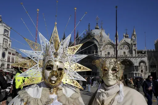 Revellers participate in the celebrations of the historic Venetian Carnival in front of St. Mark's Basilica in Venice, Italy, Saturday, Feb. 15, 2025. (AP Photo/Antonio Calanni)