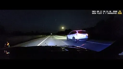 This image taken from police dash camera footage provided by the Minnesota State Patrol, shows a Minnesota trooper passing 18-year-old Sam Dutcher after the Honda Pilot he was driving began to accelerate over 100 miles per hour in western Minnesota on Tuesday, Sept. 17, 2024. The brakes and would not work and the vehicle would not shift into neutral. A trooper managed to speed in front of the Honda and told Sam by phone to crash into the rear of his squad car, allowing it to ease safely to a sto