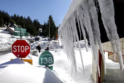 Snowfall surrounds businesses in Crestline, Calif., Friday, March 3, 2023, following a huge snowfall that buried homes and businesses. (Watchara Phomicinda/The Orange County Register via AP)