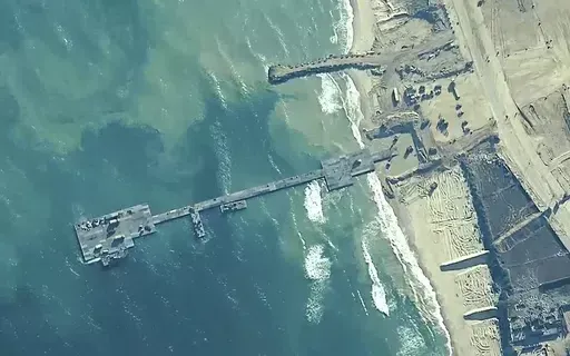 The image provided by U.S, Central Command, shows U.S. Army soldiers assigned to the 7th Transportation Brigade (Expeditionary), U.S. Navy sailors assigned to Amphibious Construction Battalion 1, and Israel Defense Forces placing the Trident Pier on the coast of Gaza Strip on May 16, 2024. A U.S. built temporary pier that had been used to deliver additional humanitarian aid into Gaza was damaged by rough seas and has temporarily suspended operations. That’s according to three U.S. officials wh