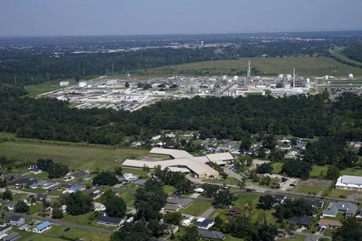 The Fifth Ward Elementary School and residential neighborhoods sit near the Denka Performance Elastomer Plant, back, in Reserve, La., Sept. 23, 2022. (AP Photo/Gerald Herbert, File)