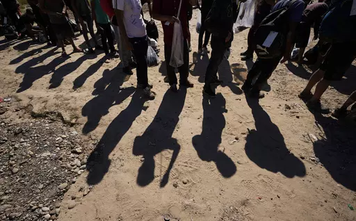 Migrants wait to be processed by the U.S. Customs and Border Patrol after they crossed the Rio Grande and entered the U.S. from Mexico, Oct. 19, 2023, in Eagle Pass, Texas. A Texas law that allows the state to arrest and deport migrants suspected of illegally entering the U.S. will remain on hold for now, a federal appeals court ruled. The order late Tuesday, March 26, 2024, from the 5th U.S. Circuit Court of Appeals followed a March 20 hearing by a three-judge panel of the court. It’s just th