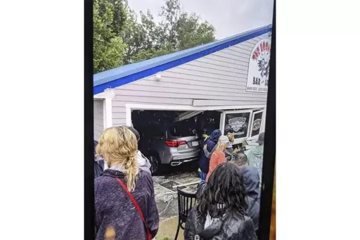 In this photo released by the Laconia Fire Department, a vehicle sits inside a restaurant after crashing through the wall on Sunday, July 2, 2023, in Laconia, NH. The car struck the busy Looney Bin Bar & Grill and injured more than a dozen patrons inside, authorities said. (Laconia Fire Department via AP)